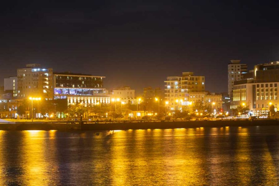 ciudad encendida de noche frente al mar