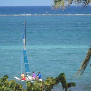 la playa azul con un catamrán